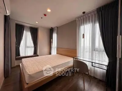 Modern bedroom with large windows and stylish decor in a contemporary apartment.