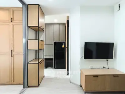 Modern apartment interior with sleek storage and mounted TV, showcasing minimalist design and efficient use of space.