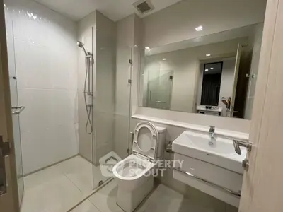 Modern bathroom with glass shower and sleek fixtures in a contemporary apartment.