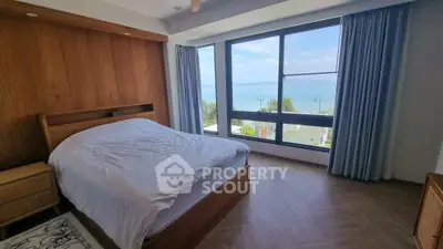 Stunning bedroom with panoramic ocean view and elegant wooden furnishings.
