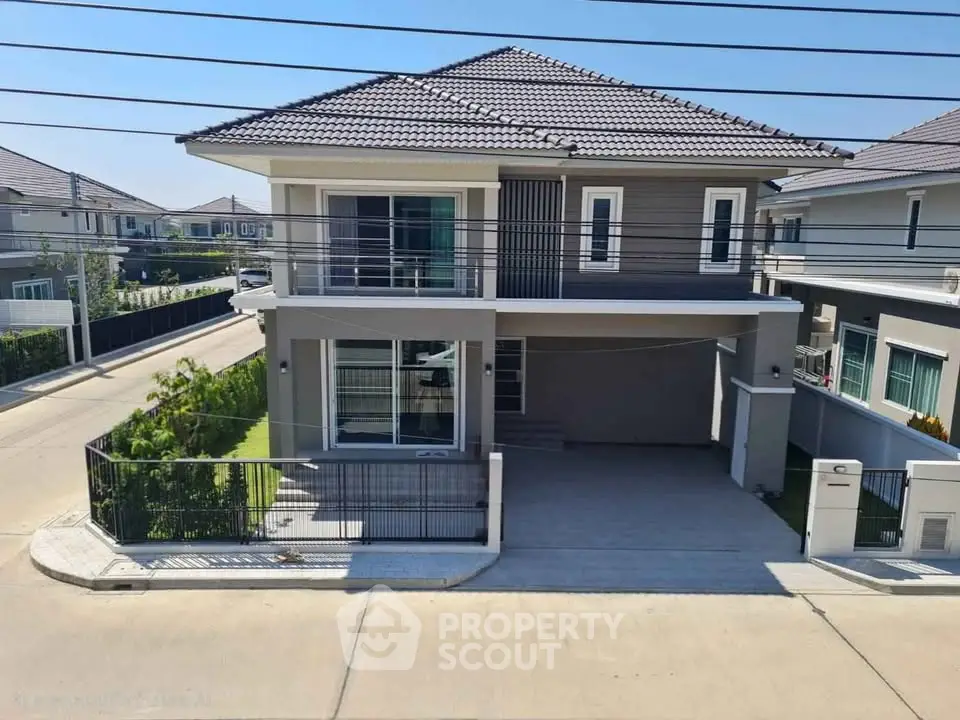 Modern two-story house with sleek design and spacious driveway in a suburban neighborhood.