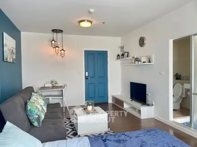 Modern living room with stylish decor and open layout, featuring a cozy dining area and vibrant blue accents.