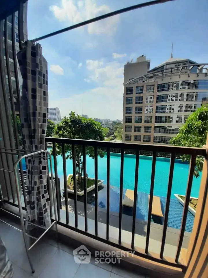 Luxurious balcony view overlooking a pristine pool and modern cityscape, perfect for urban living.
