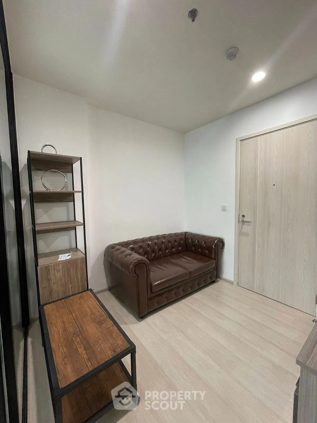 Cozy small living room with leather sofa and wooden furniture