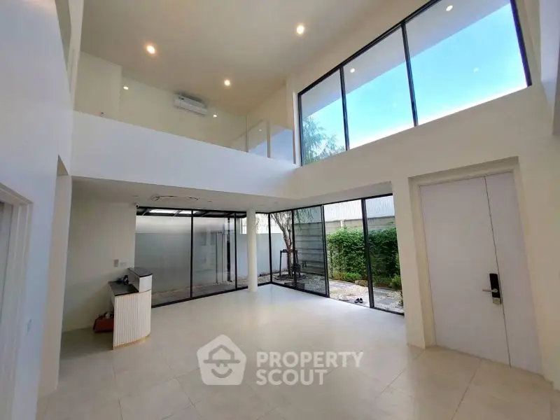 Spacious modern living room with high ceilings and large windows