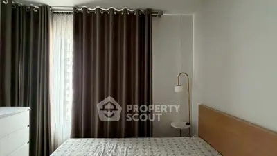 Cozy bedroom with modern decor, featuring elegant curtains and a stylish floor lamp.