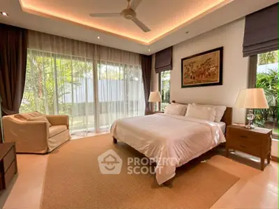 Luxurious bedroom with garden view, featuring elegant decor and ample natural light.
