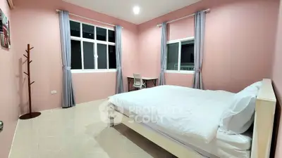 Spacious bedroom with pink walls and modern furnishings, ideal for comfort and relaxation.