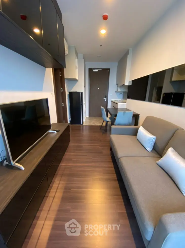 Modern living room with sleek furniture and hardwood flooring in a stylish apartment.