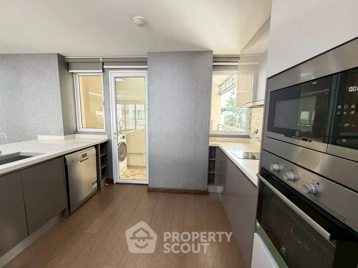 Modern kitchen with sleek appliances and wooden flooring