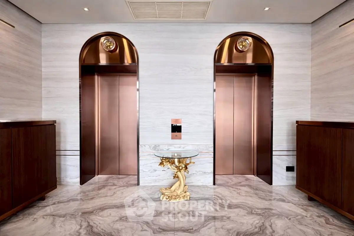 Luxurious building lobby with elegant marble flooring and stylish bronze elevators.