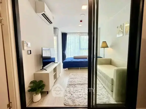 Modern living room with large window, cozy sofa, and stylish decor in a bright apartment.