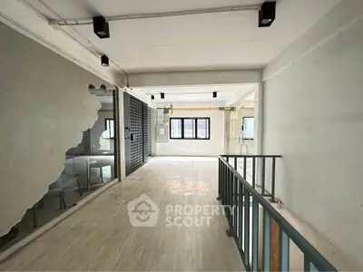 Spacious industrial-style interior with large windows and modern lighting, perfect for creative workspace or loft living.