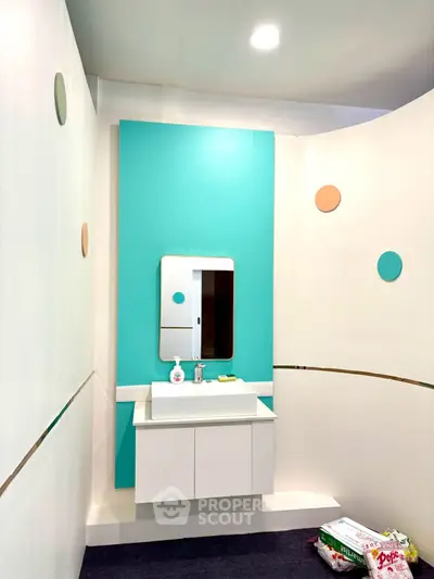 Modern bathroom with teal accent wall and sleek vanity