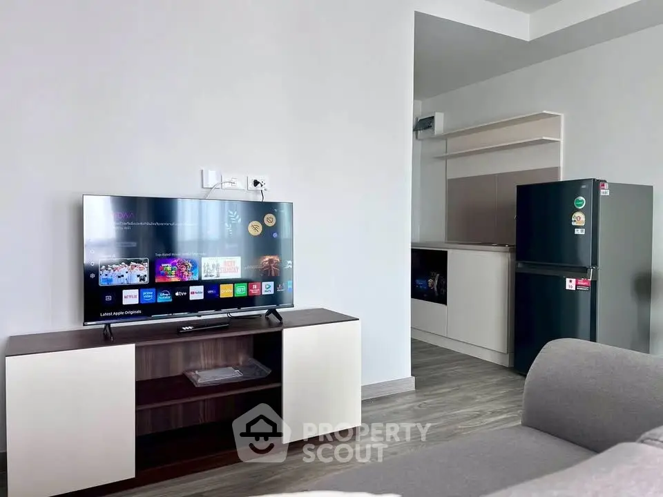Modern living room with sleek TV unit and compact kitchen area, perfect for urban living.