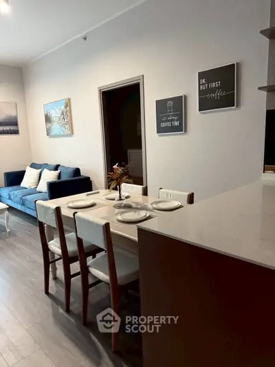 Modern open-plan living and dining area with stylish decor and cozy seating.