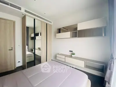 Modern bedroom with sleek mirrored wardrobe and stylish wall shelves