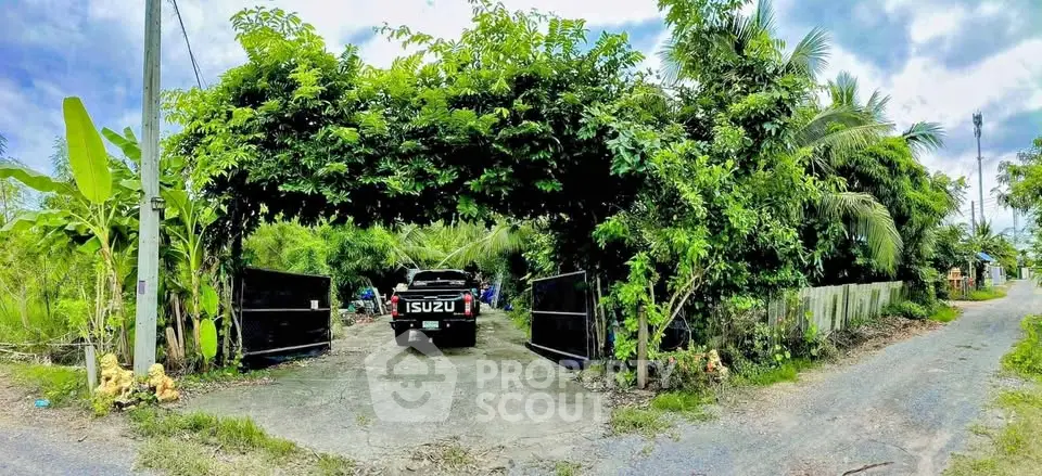 Charming rural property entrance with lush greenery and spacious driveway, perfect for nature lovers.