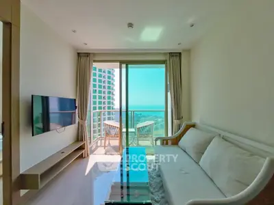 Modern living room with ocean view and balcony access in a high-rise apartment.