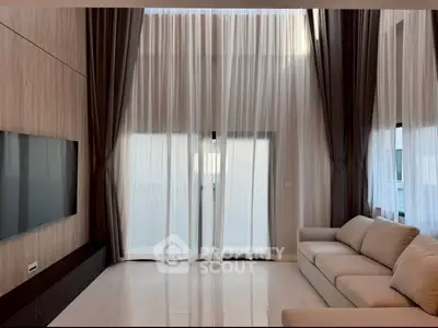 Luxurious living room with high ceilings and elegant curtains