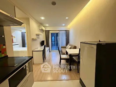 Modern open-plan living room with dining area and balcony access in cozy apartment.