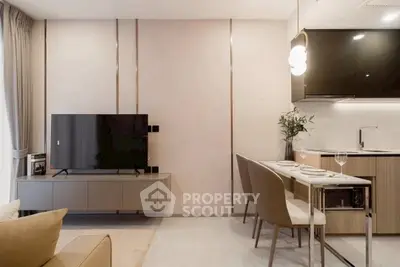Modern living room with sleek kitchen and dining area, featuring elegant decor and contemporary furniture.