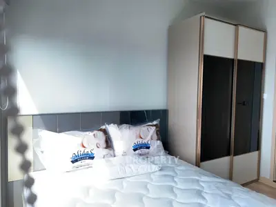 Modern bedroom with stylish wardrobe and comfortable bed in bright apartment.