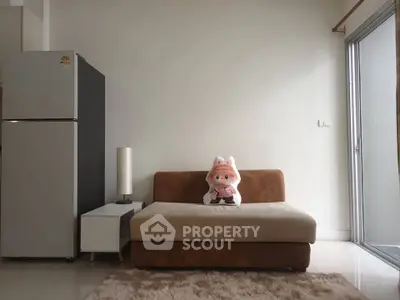 Cozy living room with plush sofa and modern fridge, perfect for relaxation.