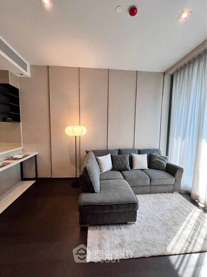 Modern living room with stylish sofa and floor lamp, featuring elegant decor and natural light.