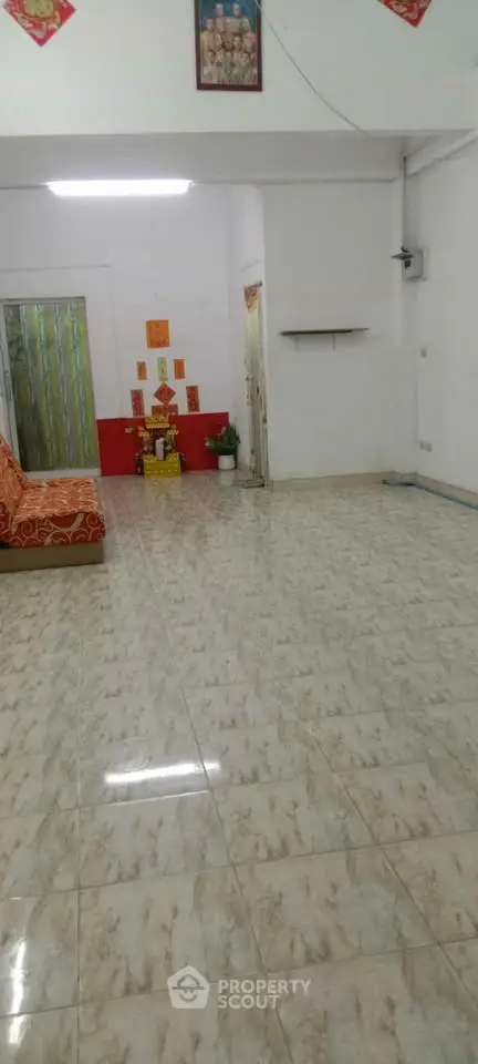Spacious living room with tiled flooring and minimal decor, ideal for customization.