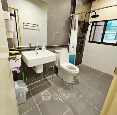 Modern bathroom with sleek fixtures and large mirror in contemporary apartment.