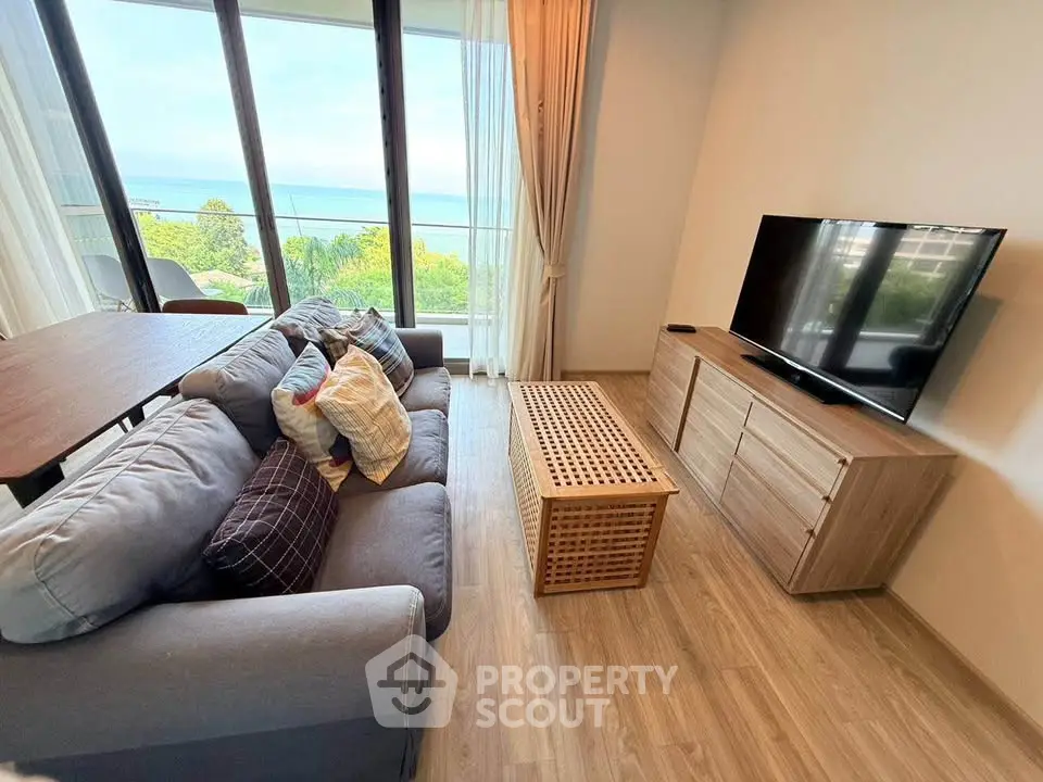 Stylish living room with ocean view, modern furniture, and large windows.