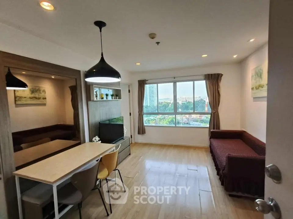 Modern living room with dining area and large window offering city view
