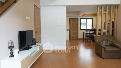 Spacious open-plan living room with modern decor and wooden flooring