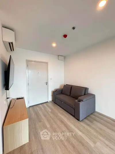 Modern living room with sleek design, featuring a comfortable sofa and wall-mounted TV, perfect for relaxation.