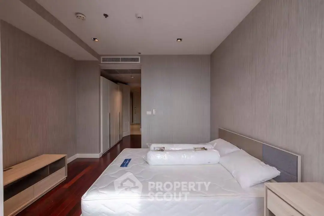 Spacious bedroom with modern design and hardwood floors in a stylish apartment.