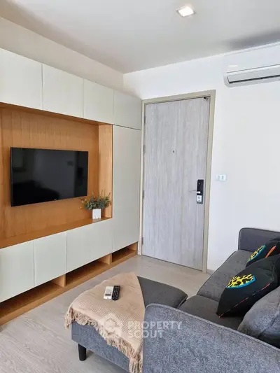 Modern living room with sleek TV unit and cozy sofa, perfect for relaxation.