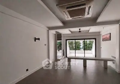 Spacious modern living room with large windows and minimalist design, perfect for natural light lovers.