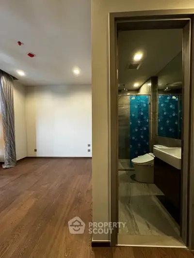 Modern apartment interior with wooden flooring and sleek bathroom design.