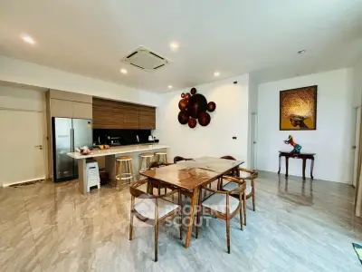 Spacious modern kitchen with open layout and elegant dining area, featuring stylish decor and ample natural light.