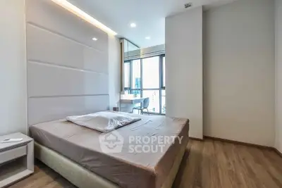 Modern bedroom with large window and sleek design in urban apartment