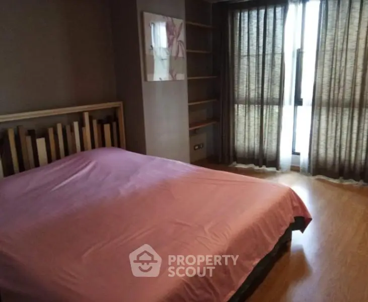 Spacious bedroom with modern decor and large window for natural light.