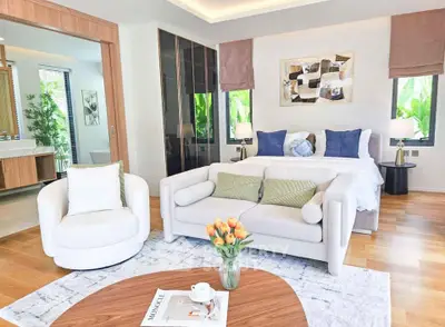 Luxurious bedroom with elegant decor and cozy seating area, perfect for relaxation.