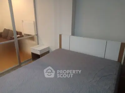 Modern bedroom with stylish bed and frosted glass partition in a cozy apartment.