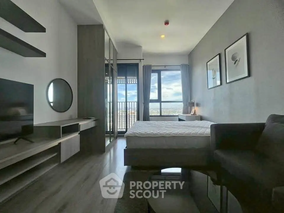 Modern bedroom with large window offering stunning city view, sleek furniture, and stylish decor.