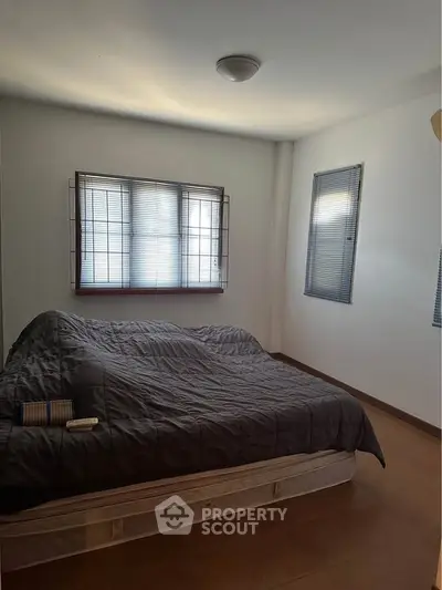 Cozy bedroom with natural light and simple decor, perfect for relaxation.