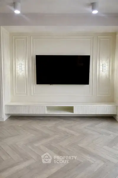 Elegant living room with modern TV setup and stylish herringbone flooring