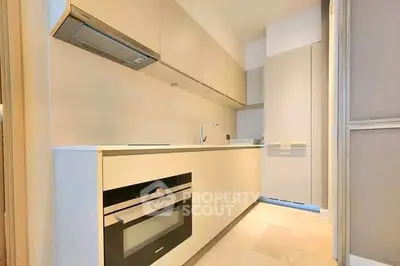 Modern kitchen with sleek cabinetry and built-in oven in a stylish apartment.