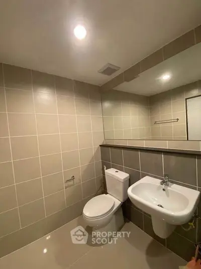 Modern bathroom with sleek tiles and contemporary fixtures in a stylish real estate property.