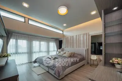 Luxurious bedroom with modern design and ample natural light, featuring elegant decor and spacious layout.